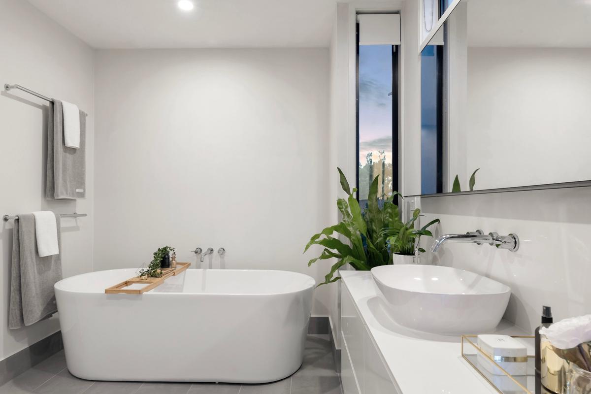 Renovated bathroom with tiled walls and a freestanding bath