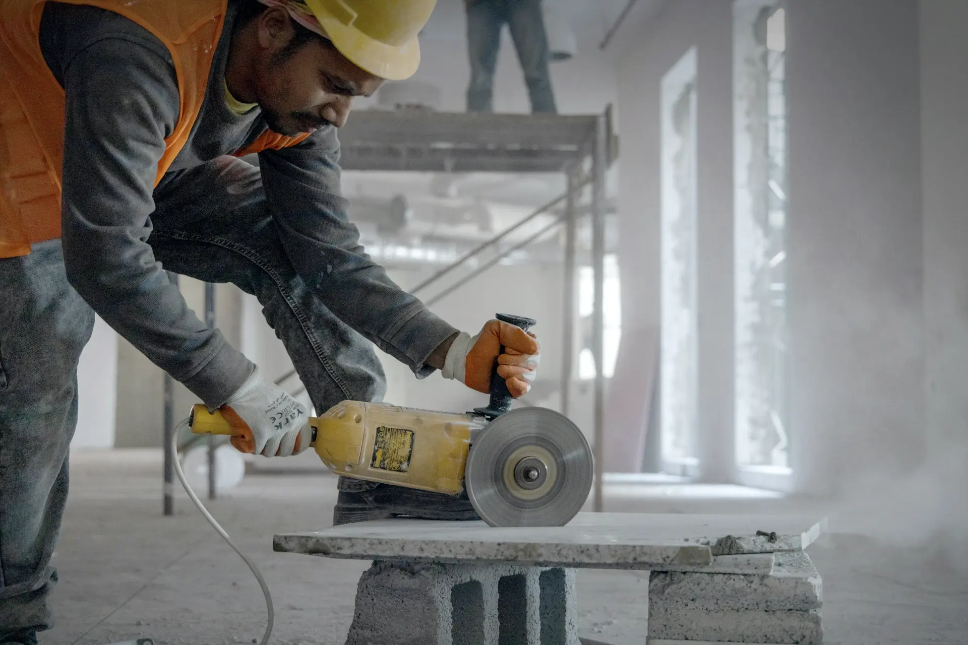 Tiler cutting a tile with an angle grinder