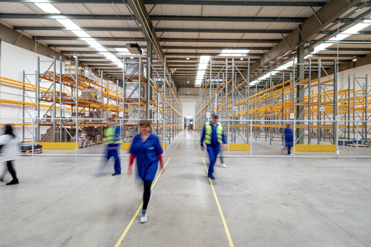 Workers walking through a warehouse aisle